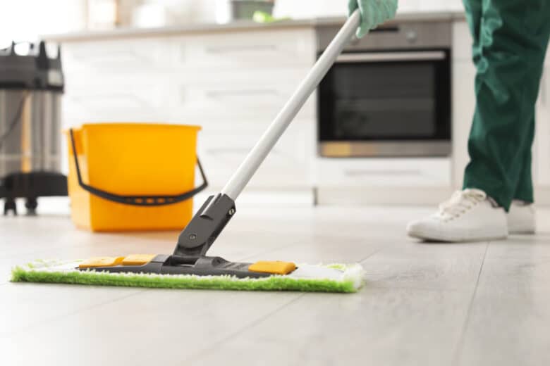 Professional janitor cleaning floor with mop in kitchen, closeup. Space for text; Shutterstock ID 1386311717; purchase_order: Nouvelle photo Multi DES; job: ; client: ; other: